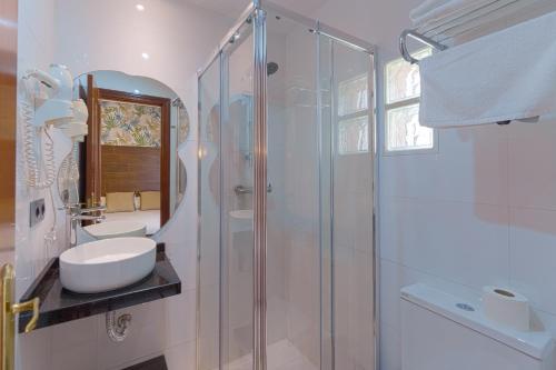 a white bathroom with a sink and a shower at Hostal Sol in Toledo