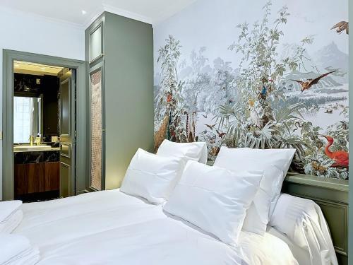 a bedroom with a bed with white pillows and a wallpaper at La suite du Brésil - Centre historique du Puy in Le Puy-en-Velay