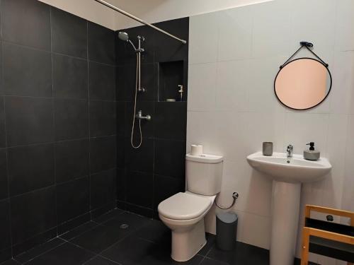 a bathroom with a toilet and a sink at Ap Doce Lar in Espargos