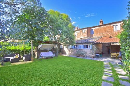 a yard with a bed and a house at Casa Guna - Happy Rentals in Asciano