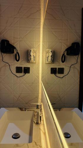 a bathroom with two sinks and two phones on the wall at شقق الياسمين الفندقية in Medina
