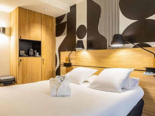 a hotel room with a bed with a towel on it at Mercure Metz Centre in Metz