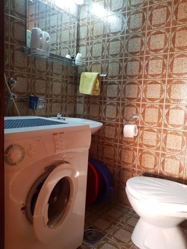 a bathroom with a washing machine and a toilet at Bar Central Point - 2BR Apartment in Bar
