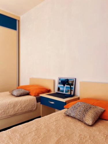 a room with two beds and a desk with a laptop at Bar Central Point - 2BR Apartment in Bar