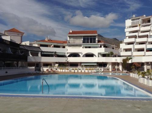 una gran piscina frente a un edificio en Apartment next to 3 excellent Beaches Costa Adeje en Adeje