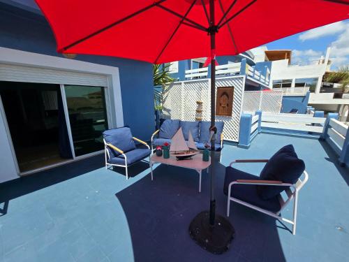 a red umbrella sitting on top of a patio at lagoon apartment 4 in Moulay Bousselham
