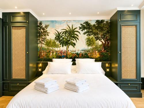 a bedroom with a large white bed with a painting on the wall at La suite Capitaine Cook - Centre historique le Puy in Le Puy-en-Velay