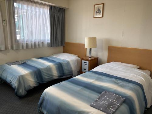 a hotel room with two beds and a window at HOTEL Dane&Kerry DogResort in Ishioka