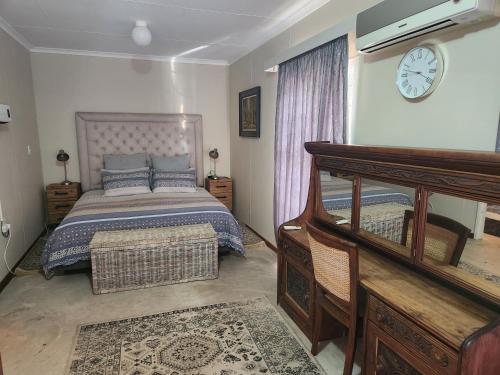 a bedroom with a bed and a clock on the wall at Pink Pepper Yard in Uniondale