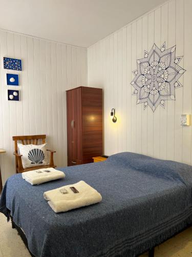 a bedroom with a bed with two towels on it at Hostería Altea in Monte Hermoso