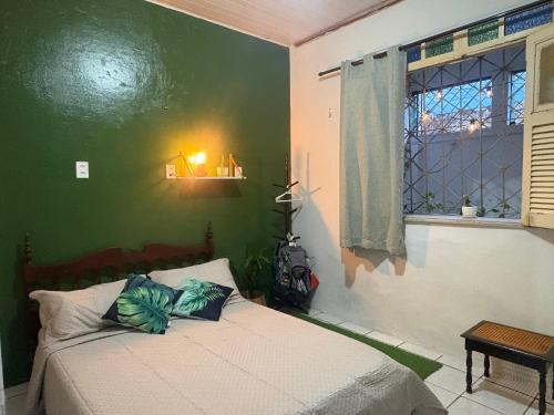 a bedroom with a bed with a green wall at Quarto confortável no Centro- Wi-Fi rápido, ar-condicionado in São Luís