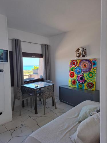 a bedroom with a table and a view of the beach at La Finestra su Stintino in Stintino