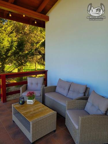 a patio with wicker chairs and a table with a table at Agroturystyka na Jęczmiennej - całe mieszkanie, 2 tarasy in Brodnica