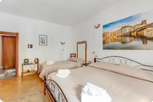 a bedroom with two beds and a painting on the wall at Ada's guest house in Bosa