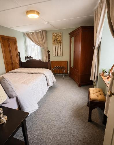 a bedroom with a large bed and a chair at Nore View House in Kilkenny