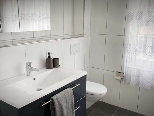 a white bathroom with a sink and a toilet at Apart Falke 2 am Wasserfall in Unterbach