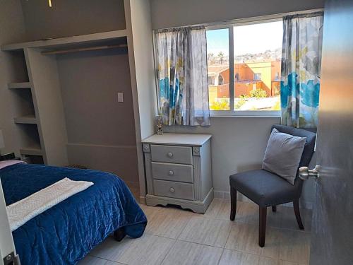 a bedroom with a bed and a chair and a window at Stunning Azul Ocean View Apartment in San Carlos