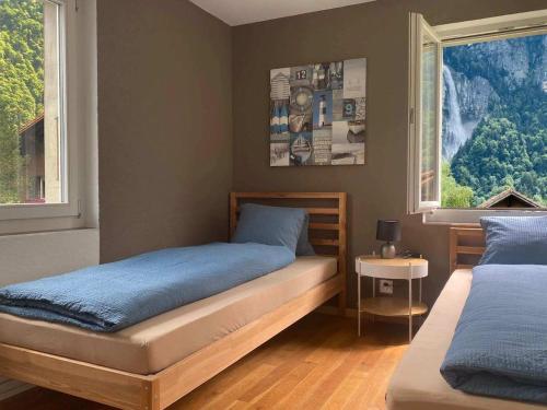 a bedroom with two beds and two windows at Apart Falke 2 am Wasserfall in Unterbach
