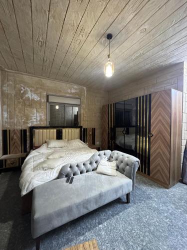 a large bedroom with a large bed and a couch at Rabab3a Hotel in Ajloun