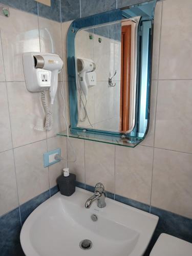 a bathroom with a sink and a mirror at RAHI Rooms in Gjilek