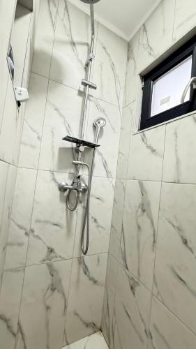a bathroom with a shower with marble tiles at Cabanele Infinyti in Colibiţa