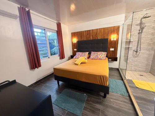 a bedroom with a large bed and a shower at Miki Miki House in Fare