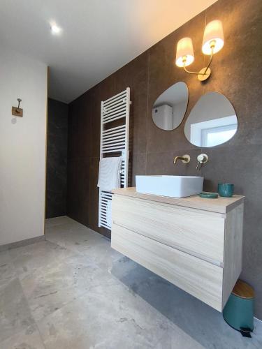 a bathroom with a white sink and a mirror at Ty Noa - 2-bedroom cottage in Saint-Just