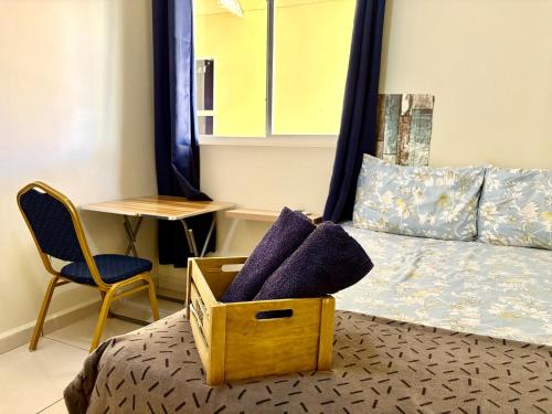 a bedroom with a bed and a chair and a desk at Bon Bini Kokolishi in Willemstad