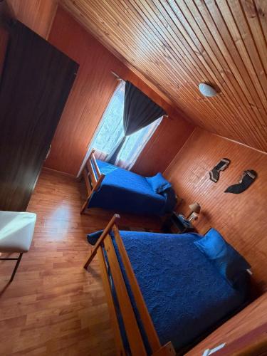 an attic room with two blue couches and a window at Cabaña el ricky in Cabrero