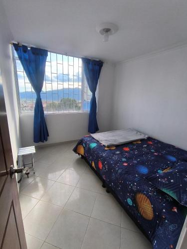 a bedroom with a bed and a large window at Brisas del Santander in Fusagasuga