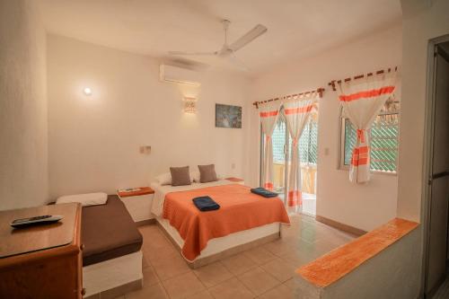 a bedroom with a bed and a desk and a window at Villa Casalet in Puerto Escondido