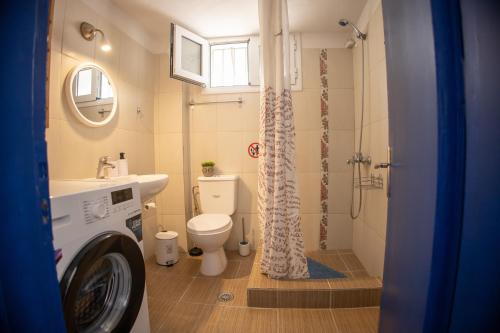 a bathroom with a toilet a sink and a shower at Blue Water Escape in Agioi Theodoroi
