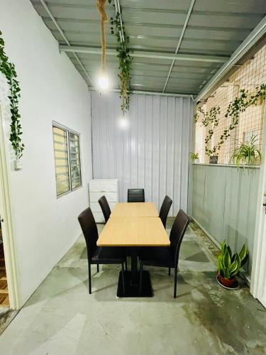 a wooden table and chairs in a room at The Cave - Adults Only in Tanah Rata