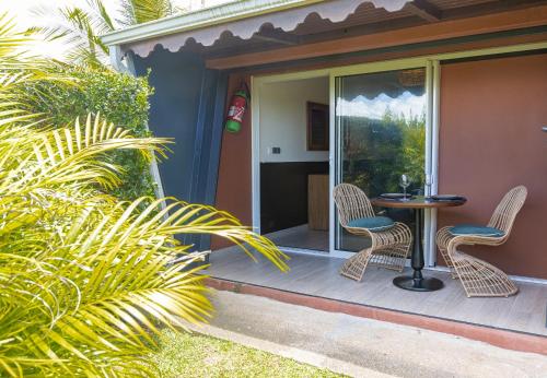 a patio with two chairs and a table on a porch at Village Soleil in Le Gosier