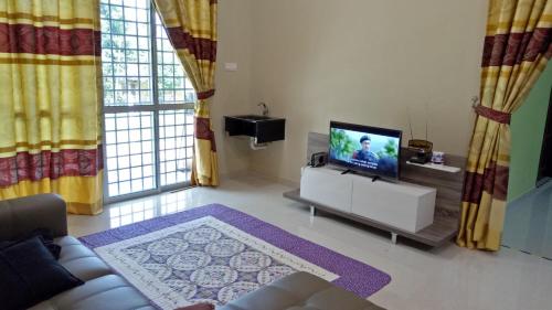 a living room with a television and a couch at DBukit Losong Villa Kuala Terengganu in Kuala Terengganu