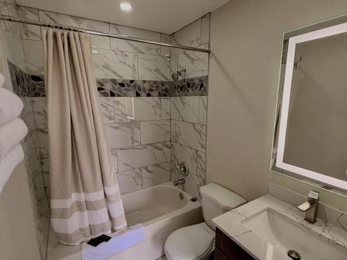 a bathroom with a tub and a toilet and a sink at Wiarton Willys Inn in Wiarton
