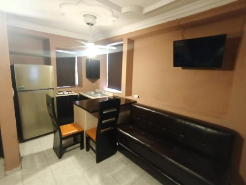 a room with a couch and a sink and a refrigerator at Garcias Suites Cuauhtémoc in Linares