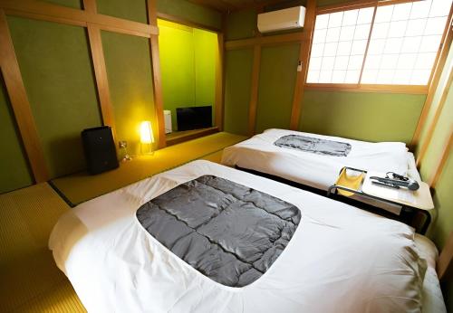 a hotel room with two beds and a television at 鈴籠城 鈴の間 - ダブルベッド2台 - 最大4名 in Nagahama
