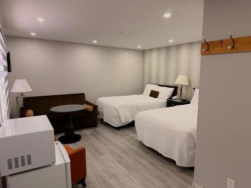 a hotel room with two beds and a table at Wiarton Willys Inn in Wiarton