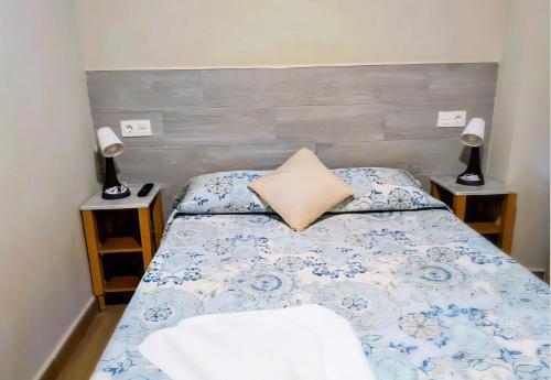 ein Schlafzimmer mit einem Bett und zwei Lampen auf Tischen in der Unterkunft ALBOR II in Gijón