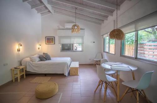 a bedroom with a bed and a table and chairs at Carumel in Villa Ciudad Parque