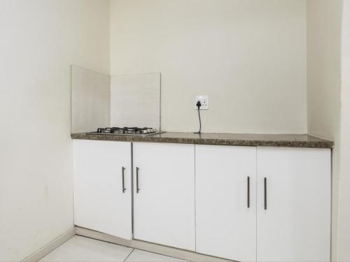a kitchen with white cabinets and a counter at La Vue in Port Shepstone