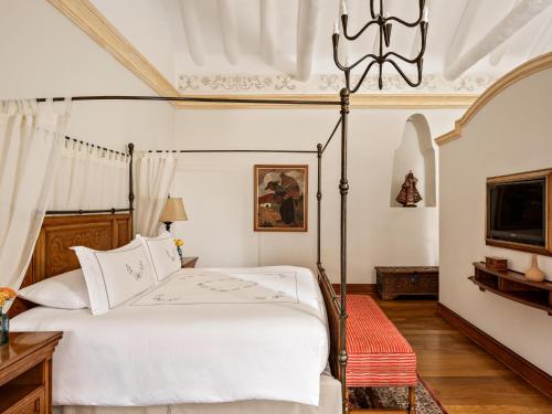a bedroom with a bed and a chandelier at Palacio Nazarenas, A Belmond Hotel, Cusco in Cusco