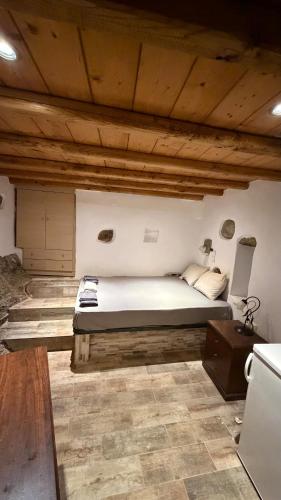 a large bed in a room with wooden ceilings at Camaraki Hill House Serifos in Serifos Chora