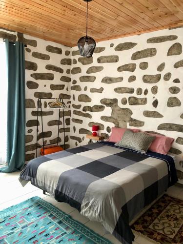 a bedroom with a stone wall with a bed at Xaminé in Água Retorta