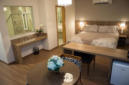 Piccola camera con letto e tavolo con sidro da tavolo. di Ives Hotel a Costa Rica