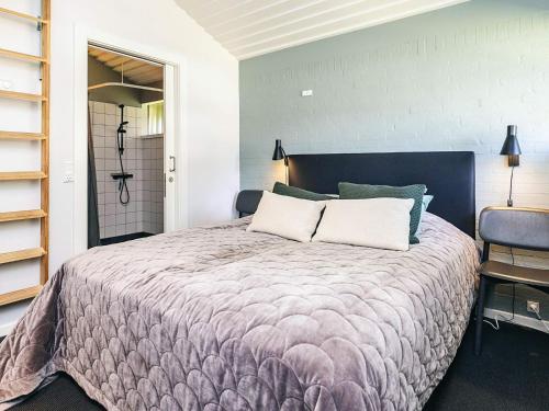 a bedroom with a large bed with two pillows at Coastal Bungalows with Beach Access in Karrebæksminde