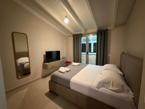 a bedroom with a large bed and a mirror at Il tramonto in Vlorë