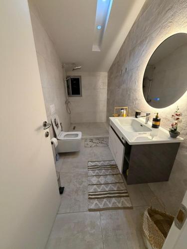 a bathroom with a sink and a toilet and a mirror at Il tramonto in Vlorë
