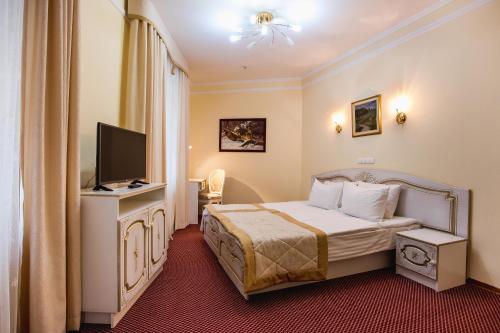 a hotel room with a bed and a television at Hotel Natalia 18 in Lviv